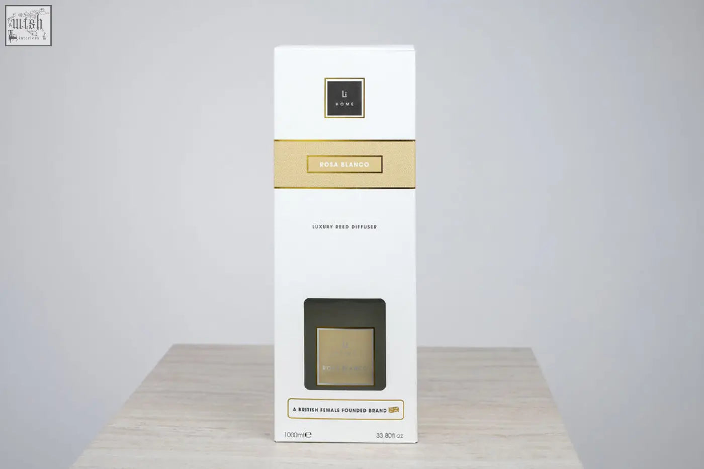 White rectangular luxury square diffuser box with gold accents and black logo featuring rosa blanco white rose scent