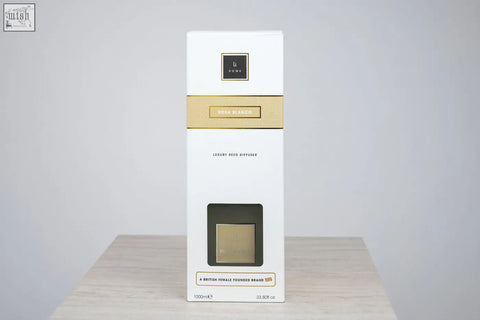White rectangular luxury square diffuser box with gold accents and black logo featuring rosa blanco white rose scent