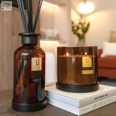 Amber-colored glass reed diffuser with black base and gold label amber fumé from luxury xxl candle amber fie 5kg