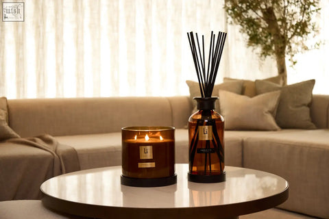 A sleek amber fie glass diffuser with black reeds and matching candle in minimalist design for luxury home scenting