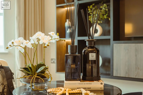 Two dark amber glass sable onyx luxury xxl room diffusers with black caps and slender sticks and white tags labeled li
