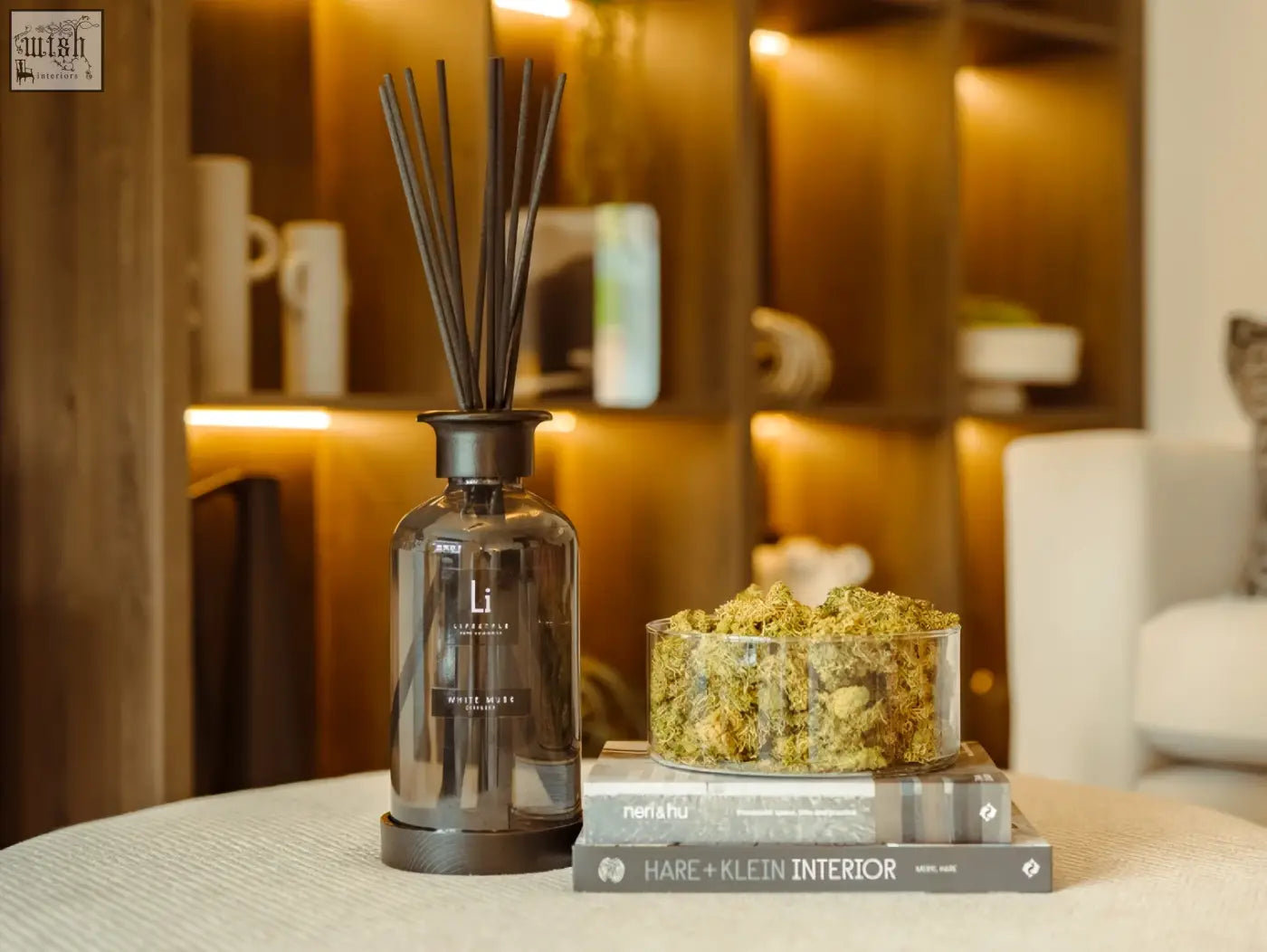Dark gray glass reed diffuser with black reeds and matte base labeled lil laboratories white moss luxury white musk scent