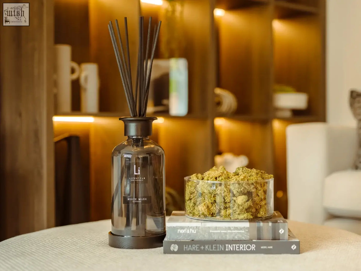 Dark gray glass reed diffuser with black reeds and matte base labeled lil laboratories white moss luxury white musk scent