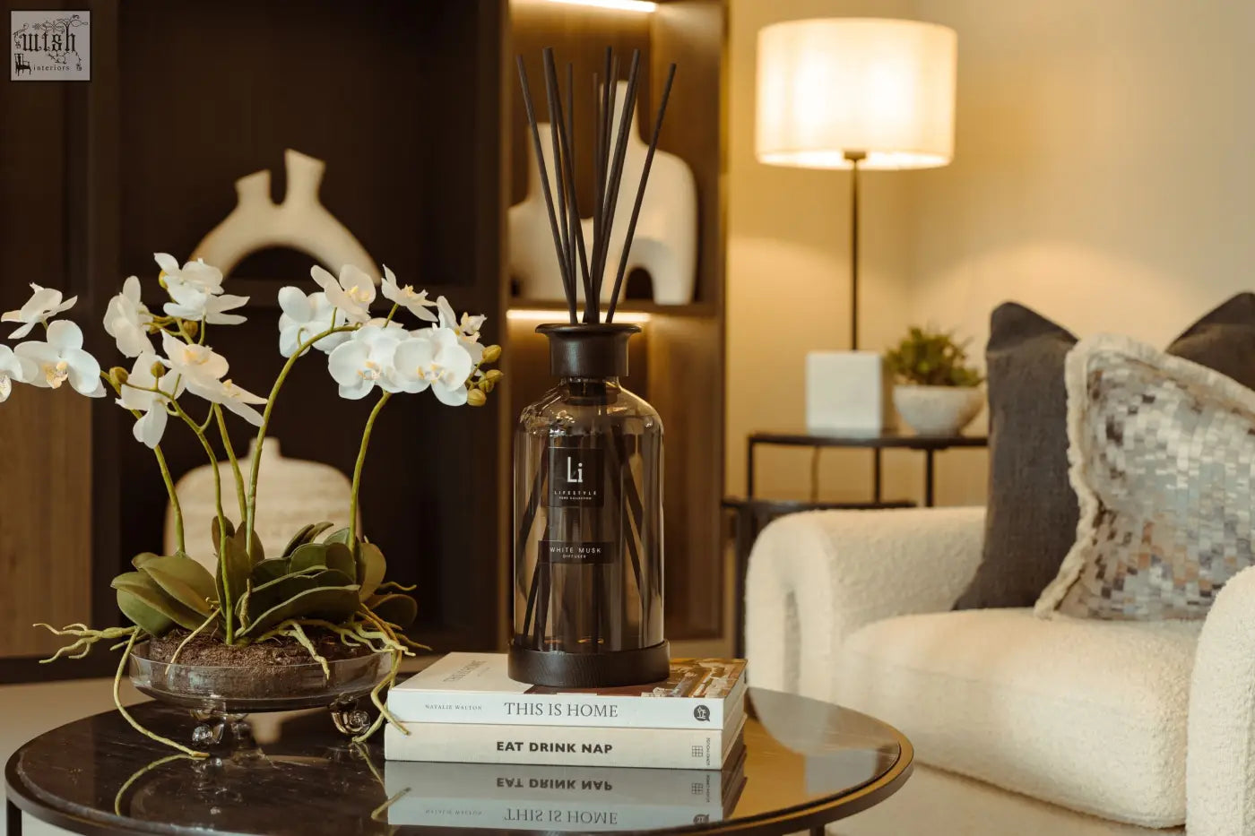 A sleek dark glass luxury xxl room diffuser with black cap and slender reeds featuring white musk scent