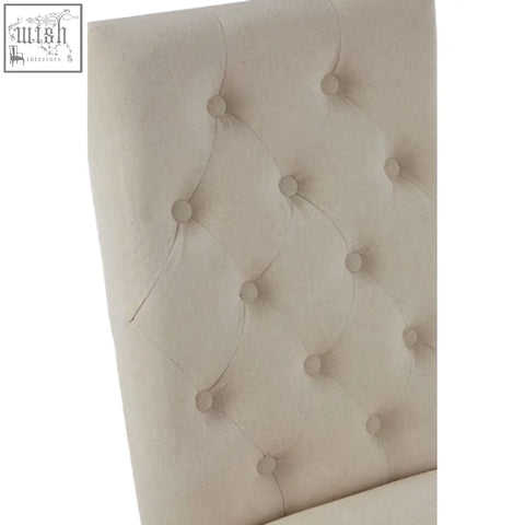 Backrest of lyon beige linen dining chair with cream tufted fabric and evenly spaced button details