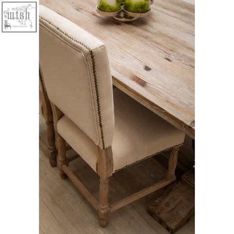 Beige linen dining chair with decorative nailhead trim and oak wood whitewash finish on wooden legs