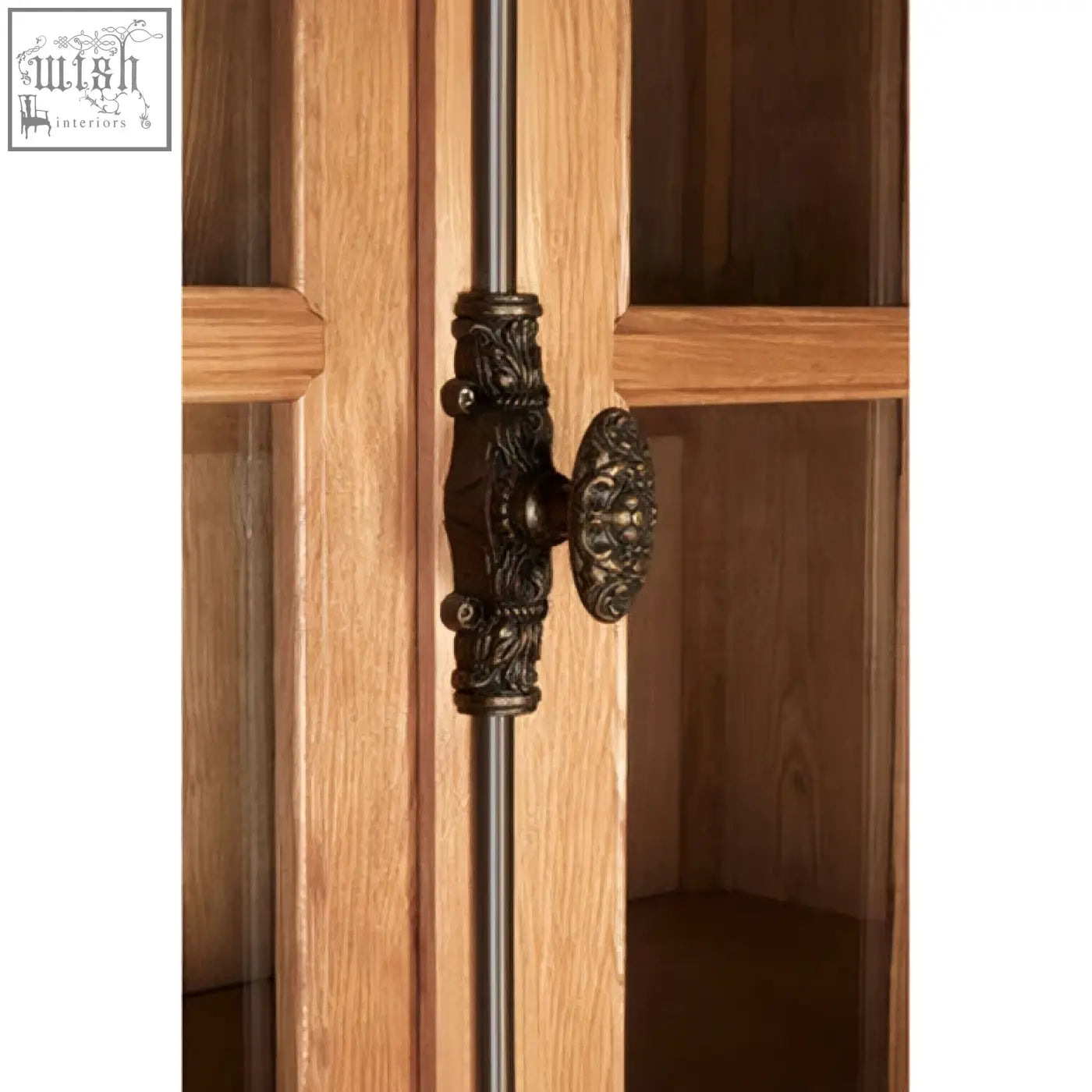 Antique bronze-finished ornate handle with scrollwork on lyon natural oak wood large cabinet door