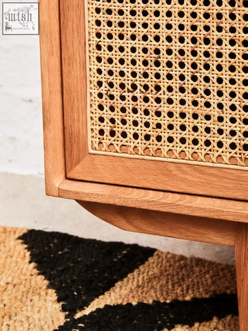 A natural oak wood door sideboard with lyon rattan woven cane panel and evenly spaced circular holes