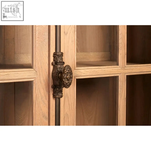 Antique bronze ornate cabinet handle with intricate scrollwork on lyon washed grey finish oak wood tall cabinet