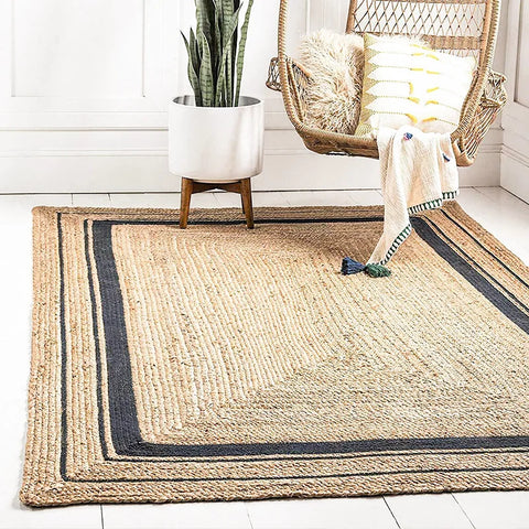 Natural fiber machine rug with textured beige center and dark navy border stripes in rectangular shape