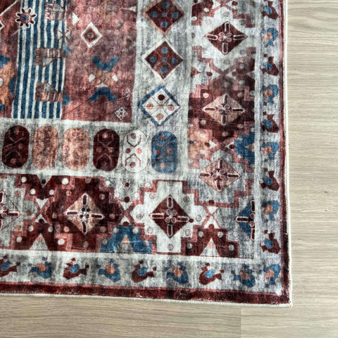 A madar vintage washable rug with faded reds blues and creams in a vintage washable wool design
