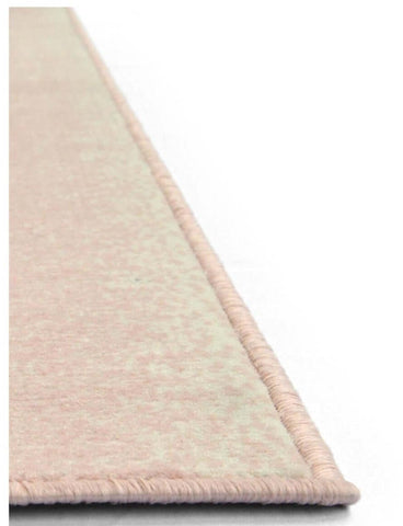 A soft blush pink maestro ombre pink rug with a textured woven surface and neatly finished edges
