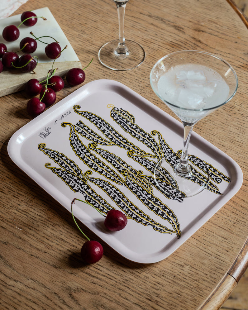 A white wooden tray called magic beans featuring black and gold stylized bean pod botanical illustration