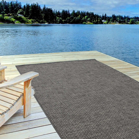 Brown woven outdoor rug on wooden dock showcasing magic outdoor rug dark grey for stylish outdoor use