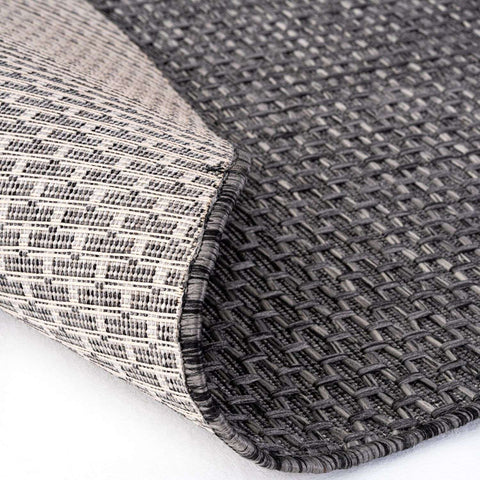 Dark grey magic outdoor rug with woven textured pattern and neatly finished edges perfect as an outdoor rug