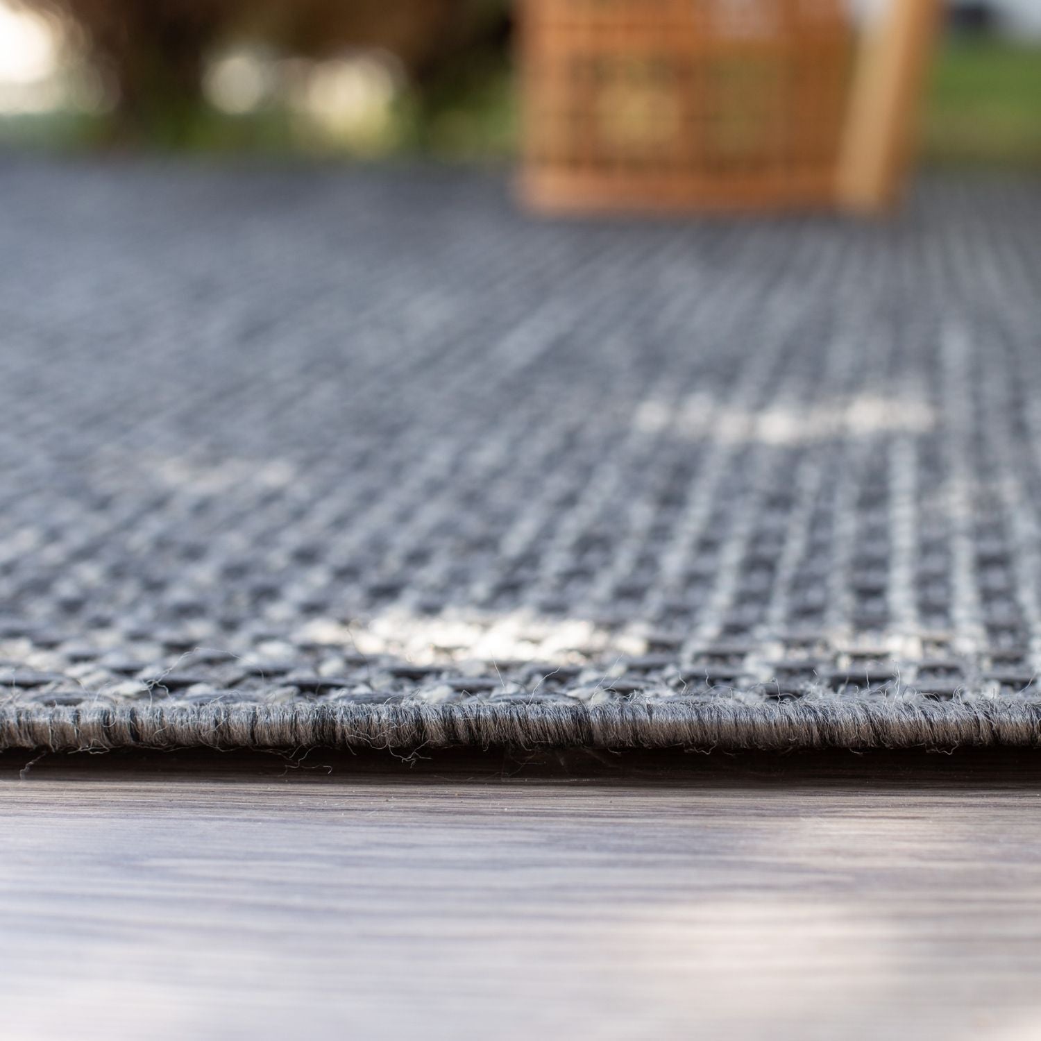 Gray woven outdoor rug with textured interlaced pattern and frayed edge magic outdoor rug dark grey 3610DG