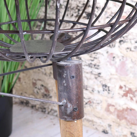 Rustic wire bird feeder with circular metal frame and wooden base next to malipara basket removable table with wooden legs