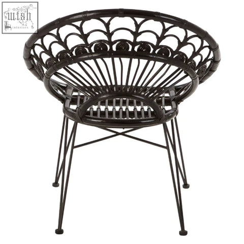 Black natural rattan manado chair with circular scalloped design and slender metal legs for stylish seating