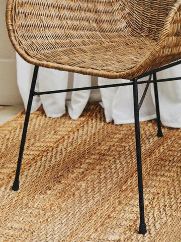 Manado curved design natural rattan chair with woven rattan seat and black metal legs for stylish seating