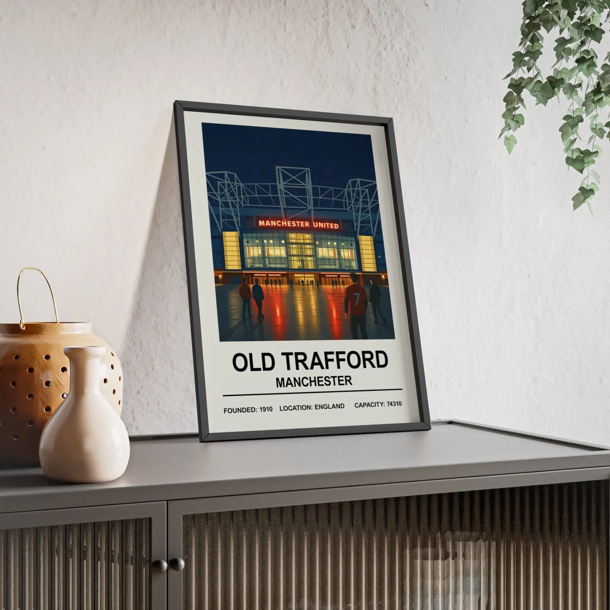 A framed manchester united trafford print wall art showing old trafford stadium illuminated at night with red and white text