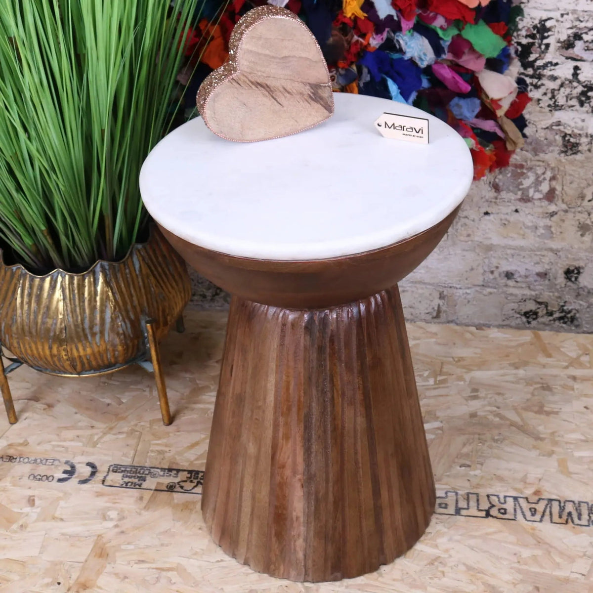 A rustic mandawa mango wood side table with white mandawa marble top and vertical grooves on the base