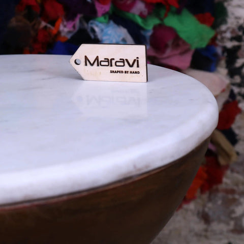 White wooden tag engraved with maravi and shaped by hand on mandawa mango wood and marble side table