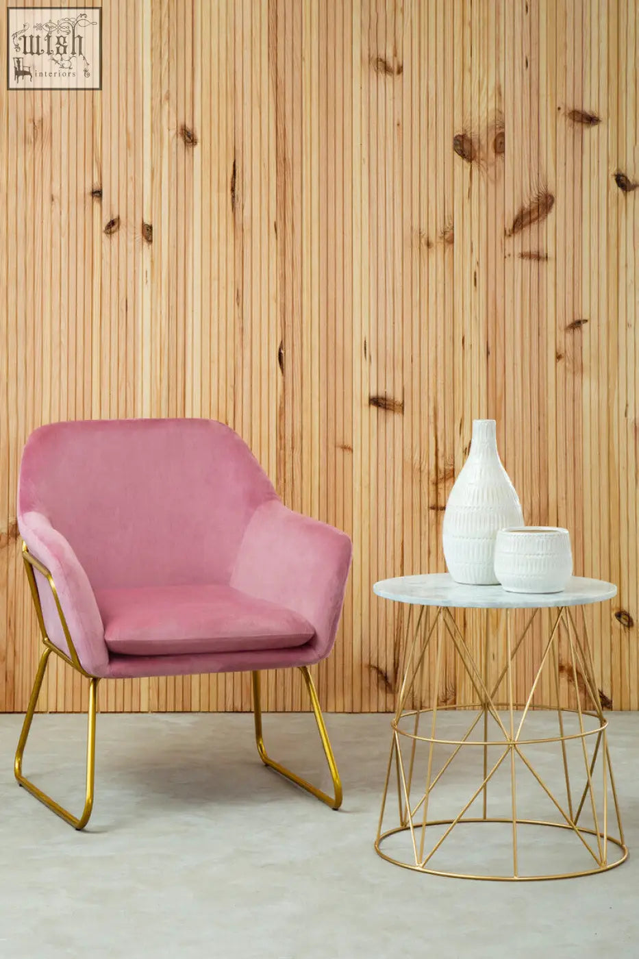 Pink velvet armchair with gold metal legs next to mandoli white marble round side table with marble round top