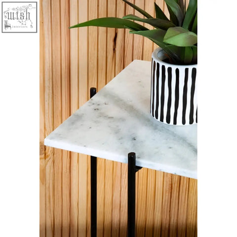 Mandoli white marble side table with white marble top and black iron frame holding a striped ceramic pot with greenery
