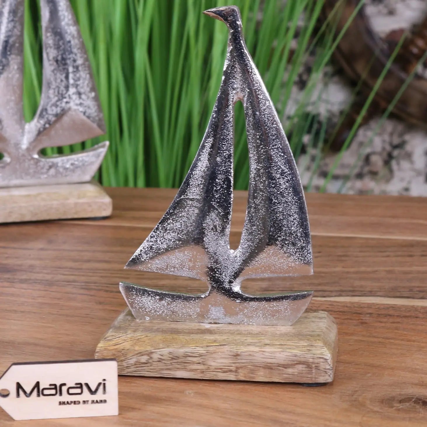 Silver metallic mandvi sailing boat ornament with textured glittery finish on rustic wooden base