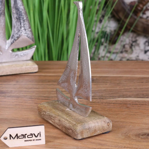 Silver metallic mandvi sailing boat ornament with textured hand-shaped finish on rustic wooden base