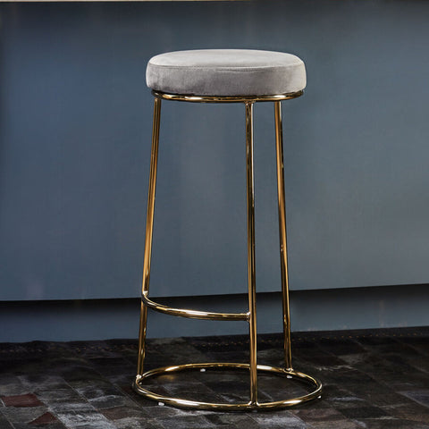 A sleek manhattan grey velvet tall bar stool with a plush grey velvet seat and shiny gold metal frame