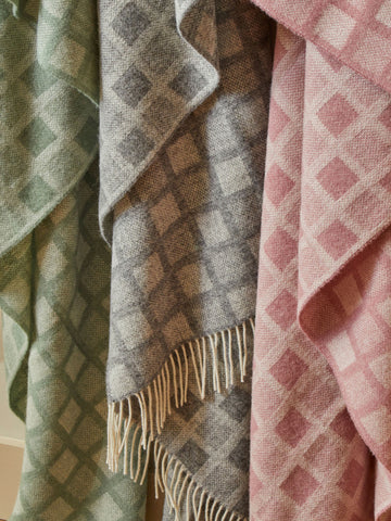 Three manhattan pure new wool throws in pastel green gray and pink with intricate square diamond patterns and fringe
