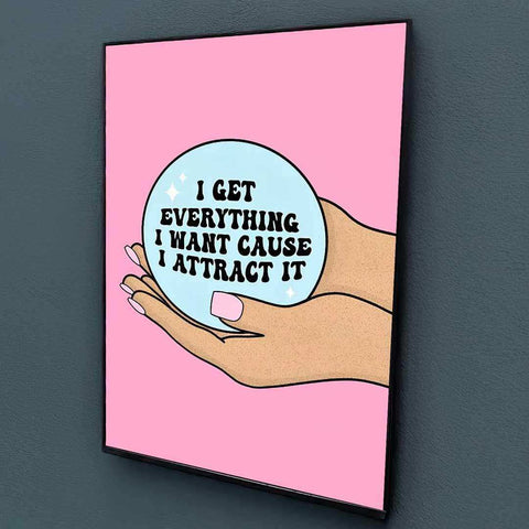 Pink-framed manifestation babe print with cartoon hand holding light blue crystal ball and black text design