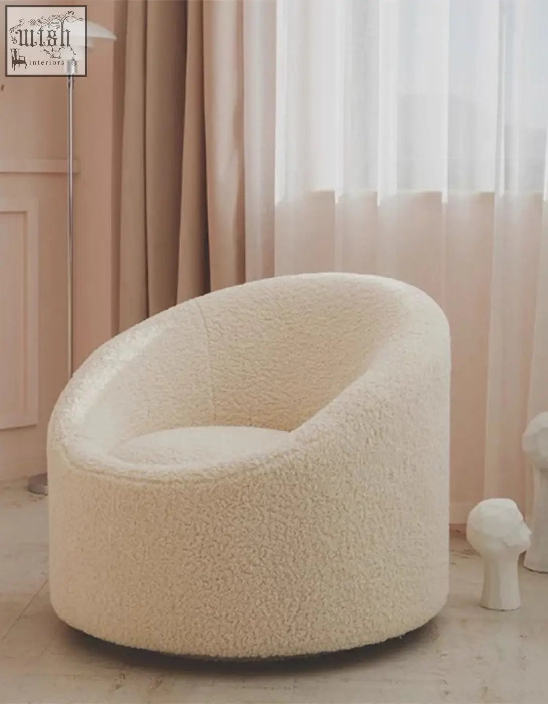 Cream-colored manon armchair with cozy rounded design and faux fur upholstery resembling plush wool armchair