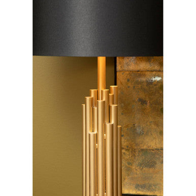 Manor table lamp with gold-toned metallic base featuring vertical tubes and a black drum shade for stylish lighting