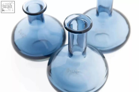 Three translucent blue glass mouth blown flasks from the manuela vase set by dutz collection with rounded bases and narrow necks