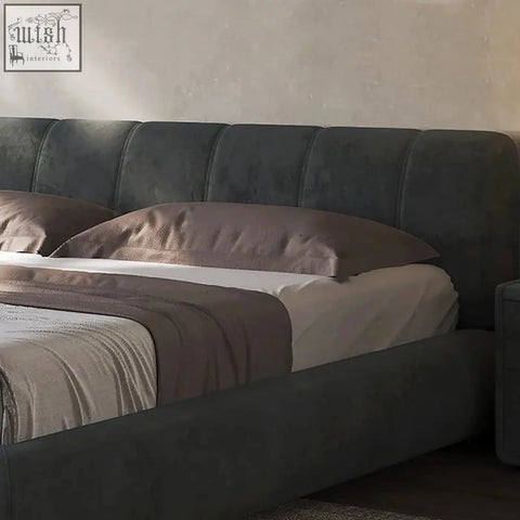 Dark gray mao bed with plush tufted headboard and footboard in a contemporary design and neutral bedding