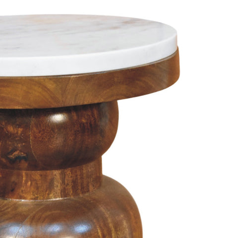 A marble top bulla side table with a round white marble top on a dark polished mango wood pedestal