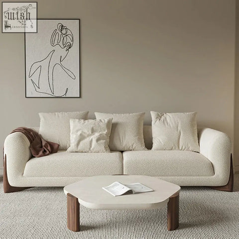 Cream-colored mariko sofa with plush texture rounded arms and dark wood legs offering plush sophistication and deep cushioning