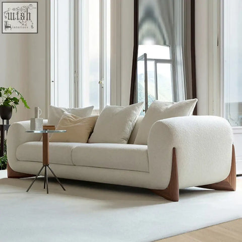 Cream-colored mariko sofa with plush texture rounded arms and wooden legs offers plush sophistication and deep cushioning