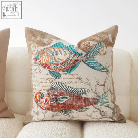 Beige marine cushion with embroidered orange red and teal fish on detailed fabric material with seaweed patterns