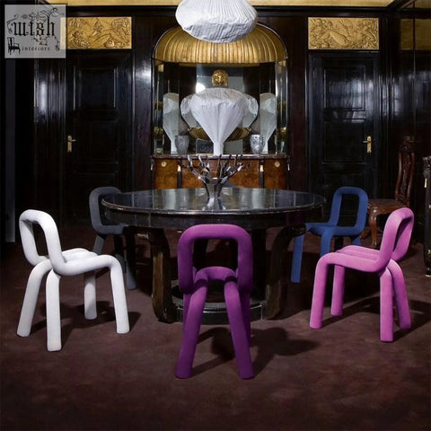 Vibrant markel dining chairs in white purple and blue molded plastic surround a dark marble dining table