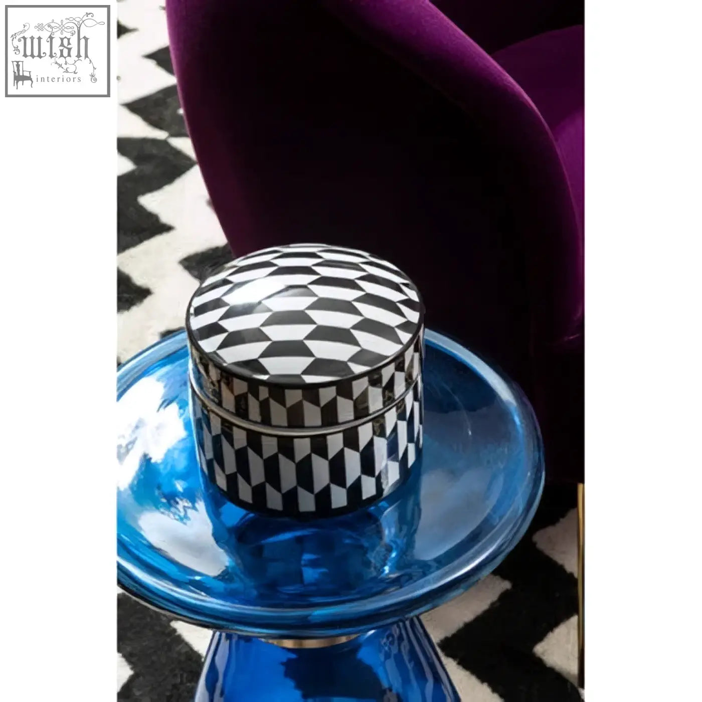 A sleek marlo large black and white white geometric ceramic trinket box on a translucent blue glass pedestal