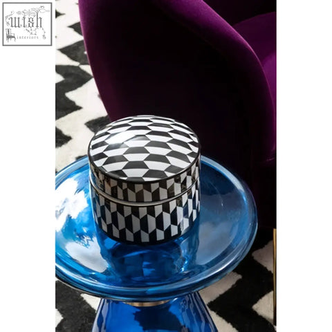 A sleek marlo large black and white white geometric ceramic trinket box on a translucent blue glass pedestal
