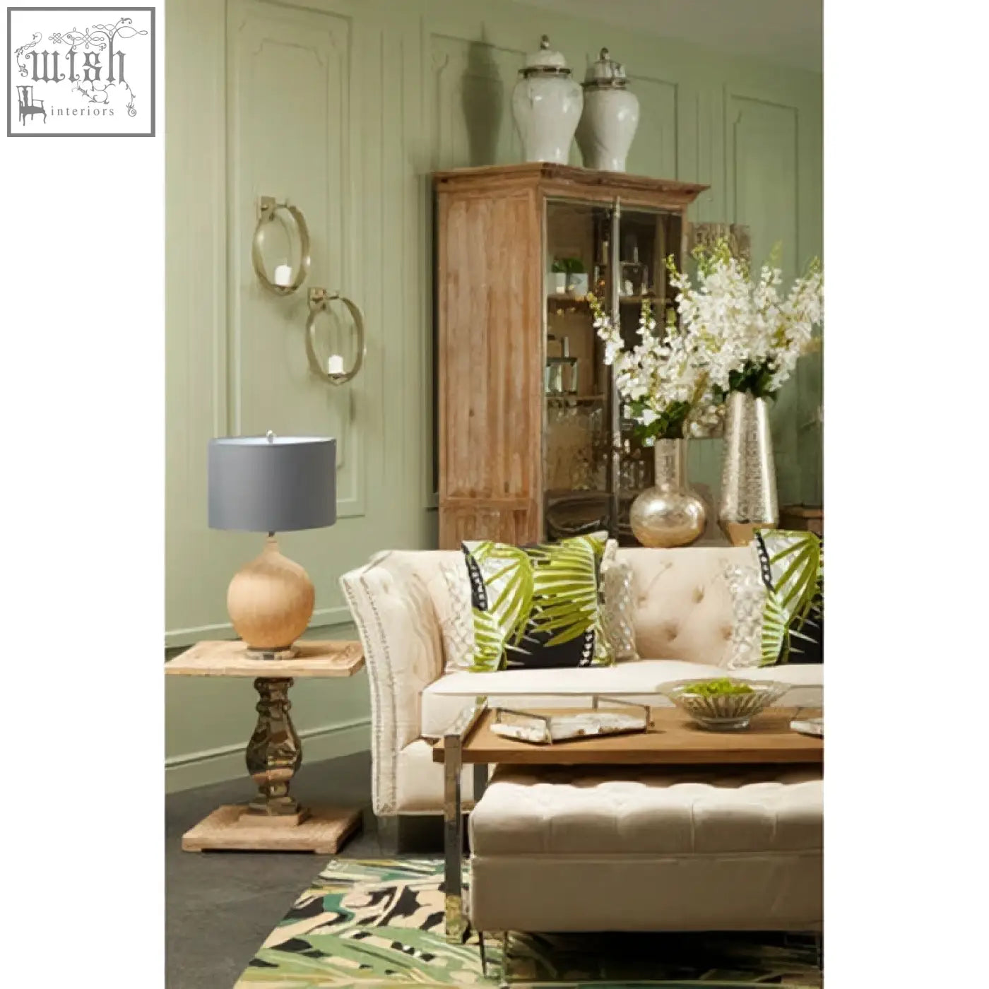 Beige tufted sofa with green and black throw pillows in a room featuring marmo marble effect large ceramic jar