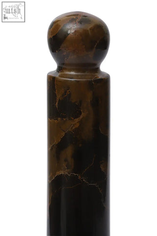 A polished brown and black marble kitchen roll holder with gold accents and a rounded top for marble kitchen roll use