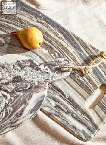 Two marble cutting boards featuring swirling gray and white patterns including a marmore rectangular black marble chopping board