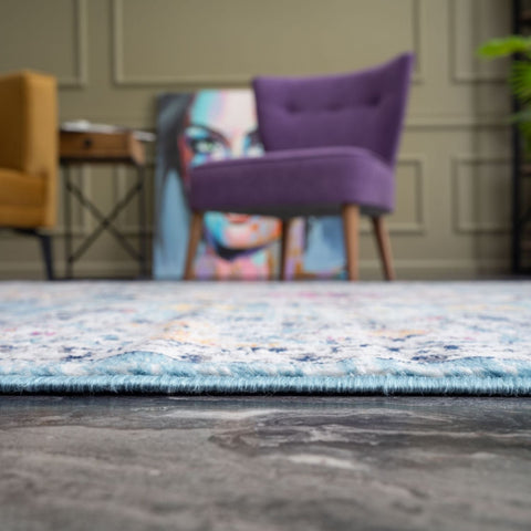 A soft purple velvet armchair with wooden legs complements the marrakech vintage rugs collection 410 in the room