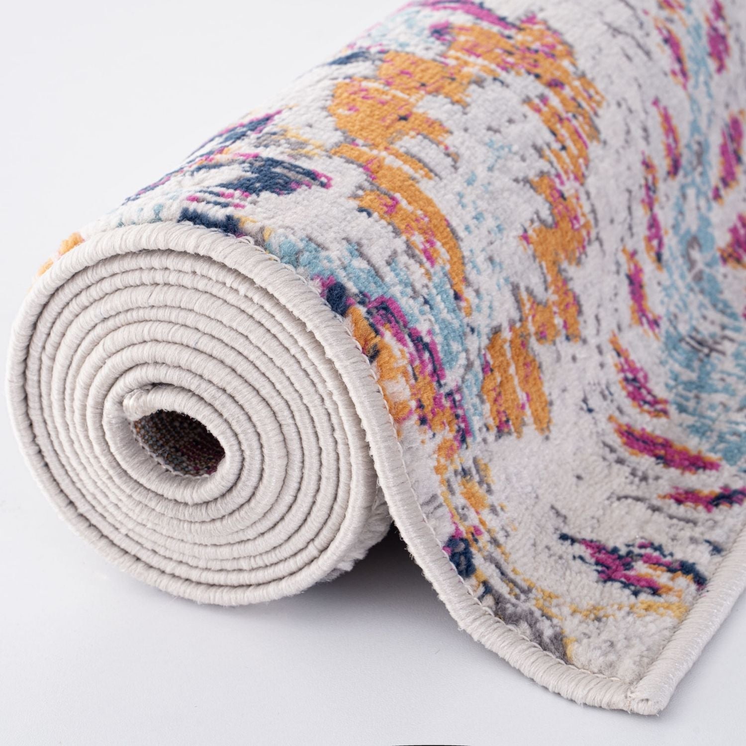 A rolled-up marrakech vintage rug with a soft textured surface and abstract pattern in muted orange pink blue and gray