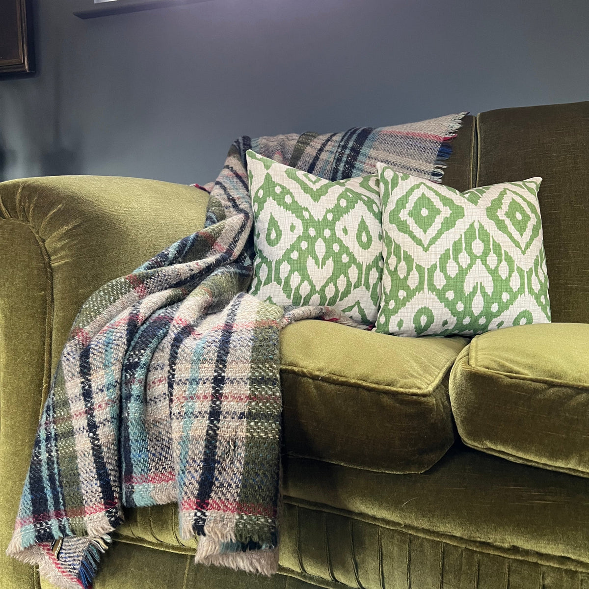 Olive green velvet sofa with marrakesh green cotton hollow fibre scatter cushions on armrests